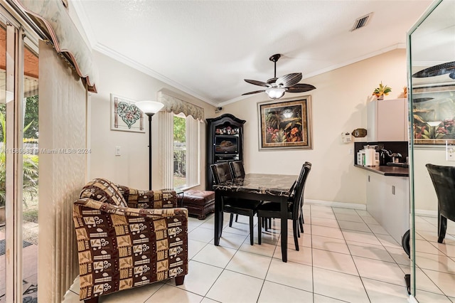 tiled dining room featuring ceiling fan and ornamental molding