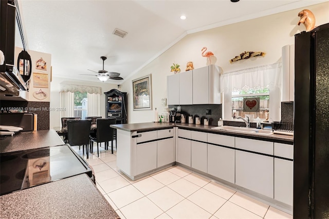 kitchen featuring white cabinetry, backsplash, and lofted ceiling