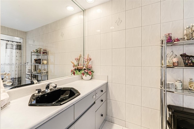 bathroom featuring vanity and tile walls