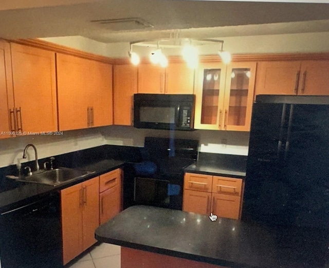 kitchen with sink, black appliances, and light tile floors