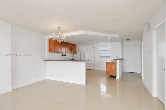 kitchen featuring kitchen peninsula, an inviting chandelier, decorative light fixtures, and white refrigerator