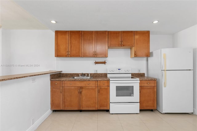 kitchen with sink, light tile patterned flooring, and white appliances