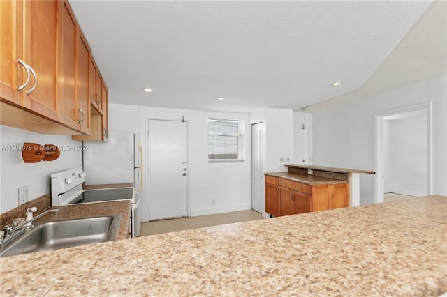 kitchen with electric stove, sink, and a textured ceiling