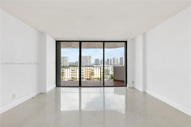 empty room featuring light tile patterned floors and floor to ceiling windows