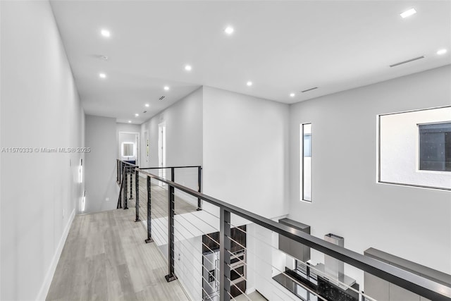 hallway with plenty of natural light and light hardwood / wood-style floors