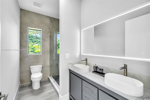 bathroom featuring an enclosed shower, vanity, hardwood / wood-style floors, and toilet