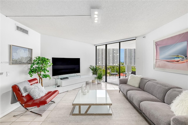 living room with floor to ceiling windows, a textured ceiling, and light tile patterned floors