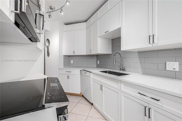 kitchen with white cabinets, sink, backsplash, light tile patterned flooring, and white dishwasher