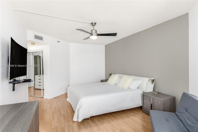 bedroom featuring a textured ceiling, light hardwood / wood-style flooring, and ceiling fan