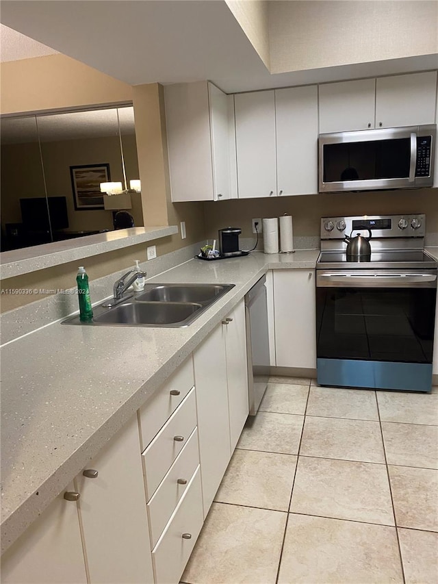 kitchen with sink, white cabinets, light tile floors, and appliances with stainless steel finishes