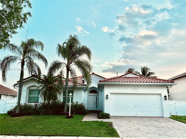 mediterranean / spanish home with a garage and a front yard