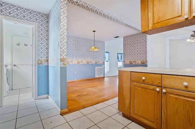 kitchen with ceiling fan, light hardwood / wood-style flooring, and decorative light fixtures