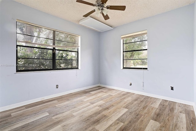 empty room with ceiling fan, a textured ceiling, and light hardwood / wood-style flooring