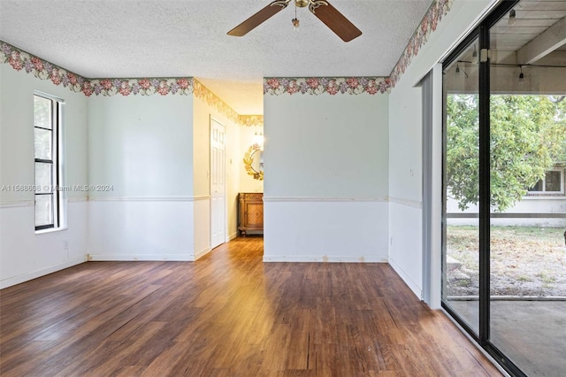 empty room featuring plenty of natural light, a textured ceiling, and hardwood / wood-style flooring