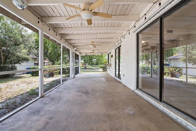 unfurnished sunroom featuring ceiling fan, beam ceiling, and wooden ceiling