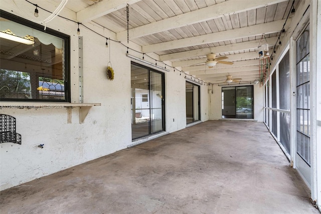 unfurnished sunroom featuring beamed ceiling, ceiling fan, and wood ceiling