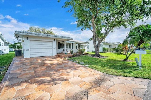 ranch-style home with central air condition unit, a garage, and a front yard