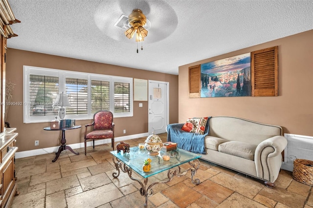 living room with tile patterned floors, a textured ceiling, and ceiling fan