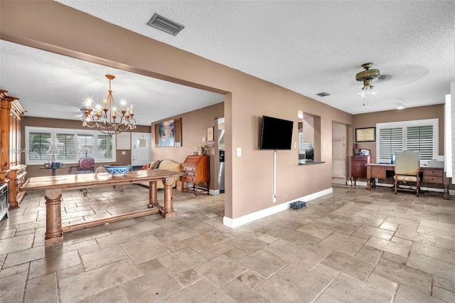 tiled dining space featuring a textured ceiling and ceiling fan with notable chandelier