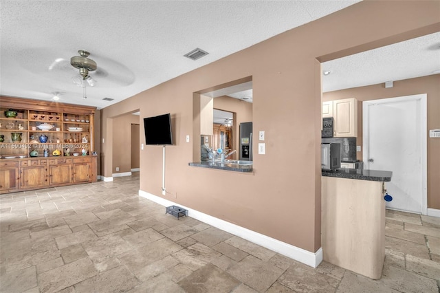 tiled living room featuring a textured ceiling and ceiling fan