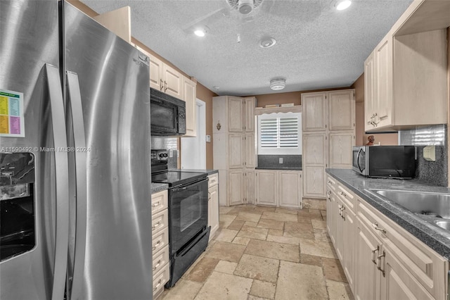 kitchen featuring sink, a textured ceiling, black appliances, and light tile patterned floors