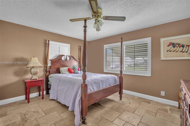 bedroom with a textured ceiling, light tile patterned floors, and ceiling fan