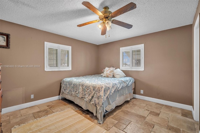 tiled bedroom with a textured ceiling and ceiling fan