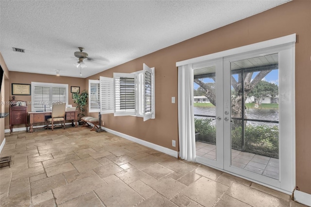 interior space featuring a textured ceiling, french doors, light tile patterned floors, and ceiling fan