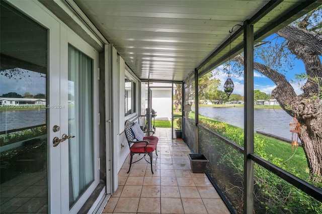 unfurnished sunroom featuring a water view and a wealth of natural light