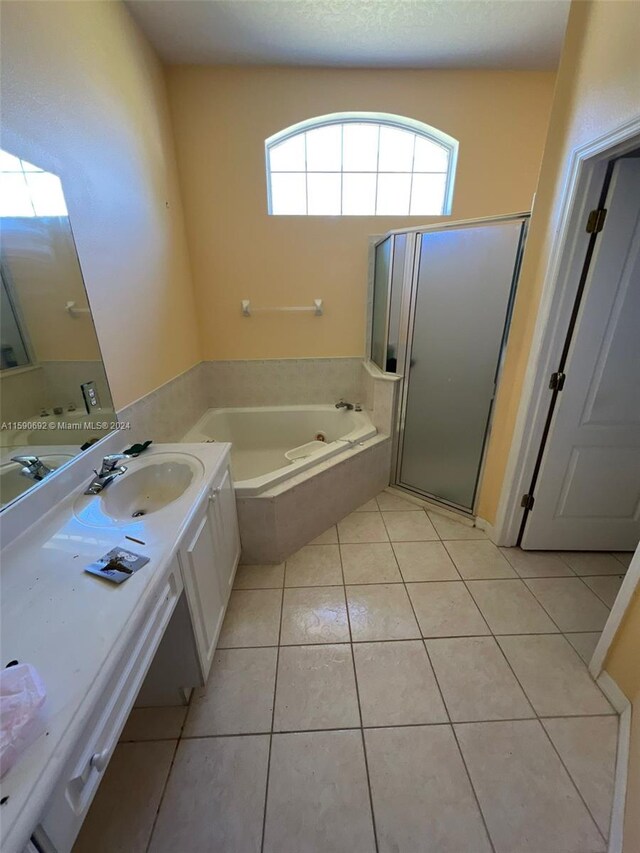 bathroom with tile flooring, separate shower and tub, and vanity