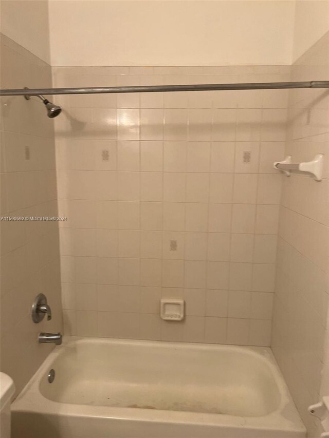 bathroom featuring toilet and tiled shower / bath combo