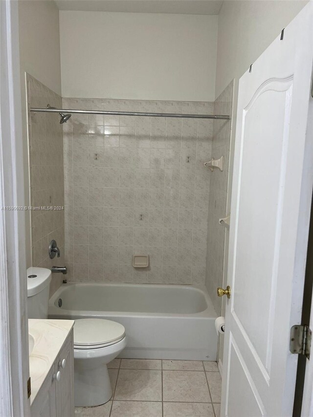 full bathroom with tiled shower / bath, tile flooring, toilet, and vanity