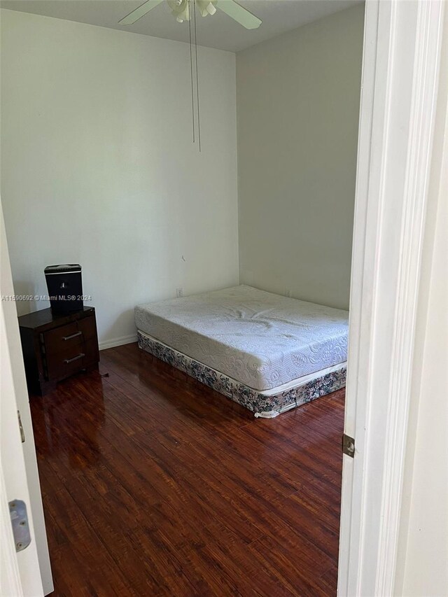 unfurnished bedroom featuring ceiling fan and dark hardwood / wood-style flooring