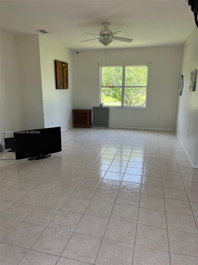 tiled empty room with ceiling fan