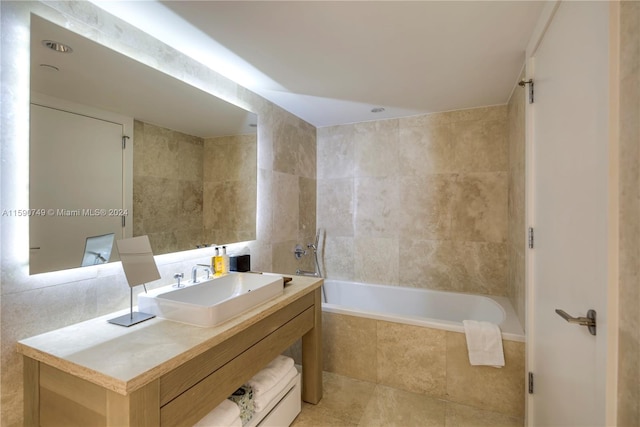 bathroom featuring tiled shower / bath combo, vanity with extensive cabinet space, tile floors, and tile walls