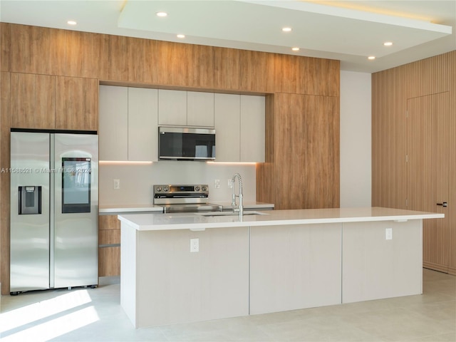 kitchen featuring appliances with stainless steel finishes, sink, a spacious island, and white cabinets