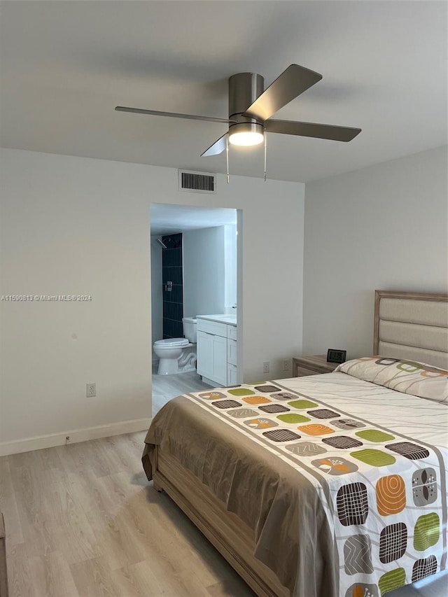 bedroom featuring light wood-type flooring, ensuite bath, and ceiling fan