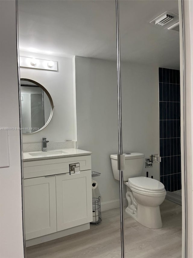 bathroom featuring hardwood / wood-style flooring, toilet, and vanity