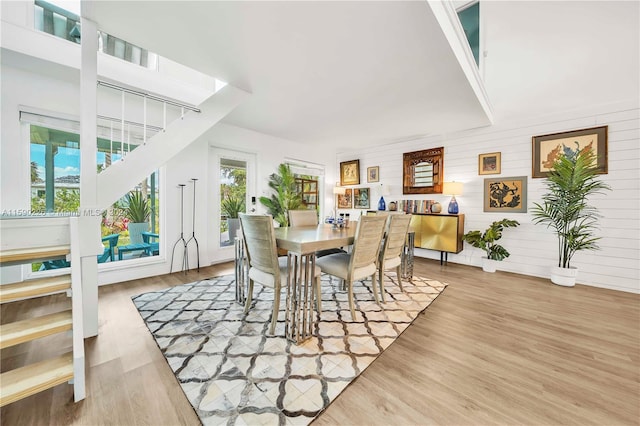 dining room with wooden walls and light wood-type flooring