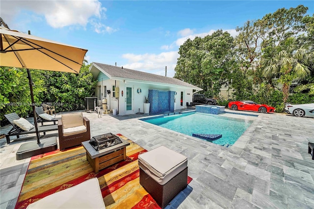 view of swimming pool with an outdoor living space with a fire pit and a patio area