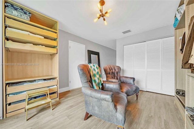 living area featuring a notable chandelier and light hardwood / wood-style flooring