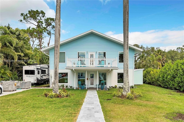 view of front facade with a front lawn and a balcony