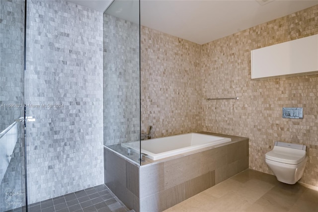 bathroom featuring a relaxing tiled bath, tile walls, toilet, and tile floors