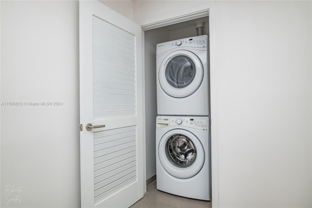 clothes washing area with stacked washer and dryer and light tile flooring