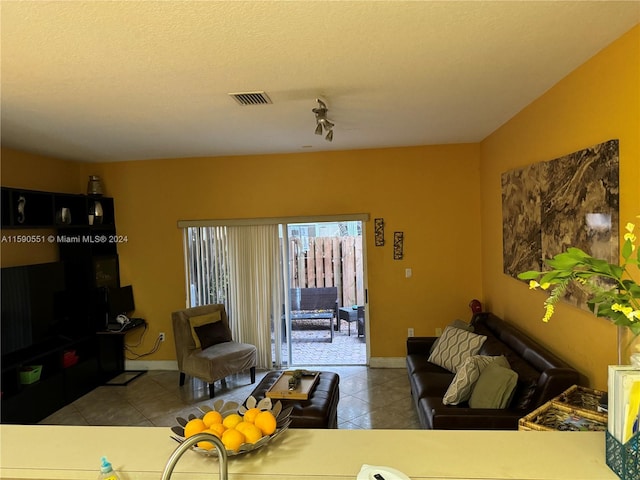 living room with light tile patterned flooring and a textured ceiling