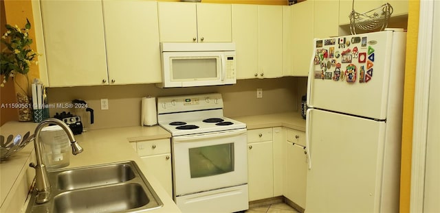 kitchen featuring sink, white appliances, and light tile patterned floors