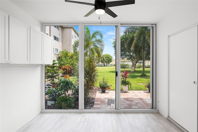 doorway with ceiling fan and light hardwood / wood-style floors