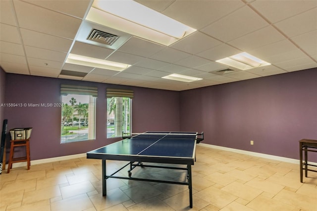 recreation room featuring light tile flooring and a drop ceiling