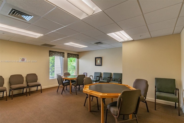 carpeted dining area with a drop ceiling