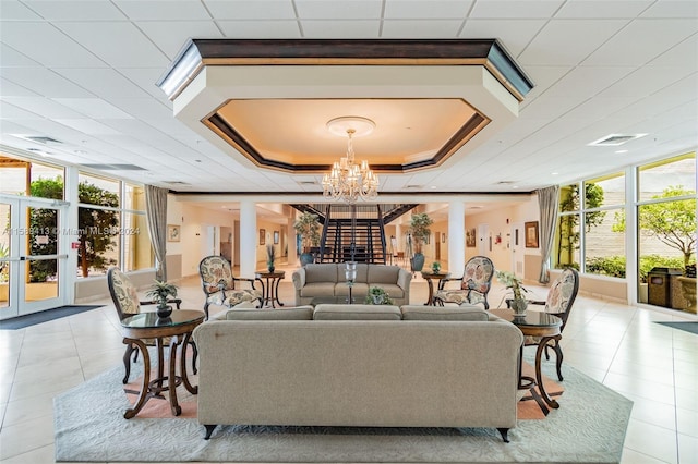 living room featuring a wealth of natural light, a chandelier, and light tile floors